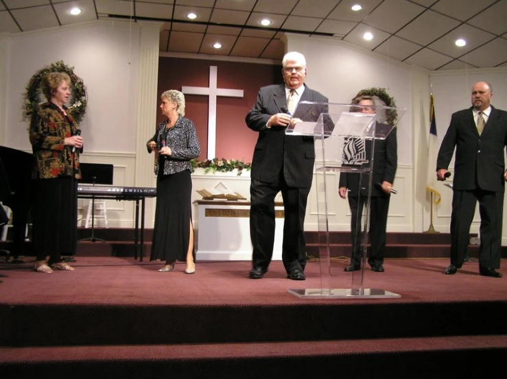 several people in suits and ties standing on stage