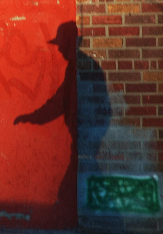 there is a person shadow on the red wall