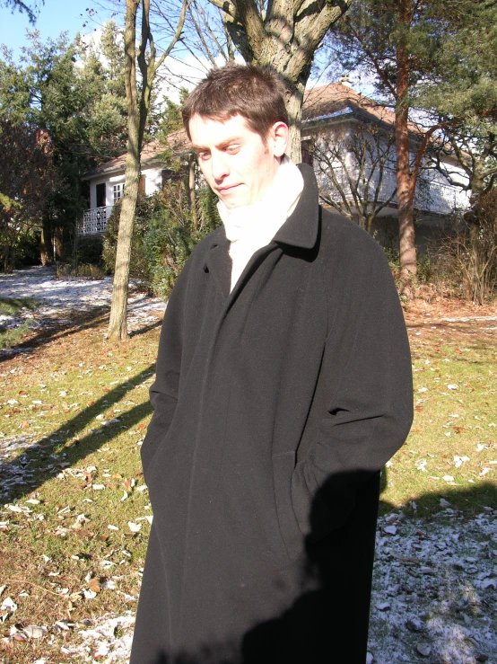 a young man posing in a yard for a picture