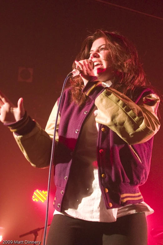 a woman standing on a stage holding a microphone