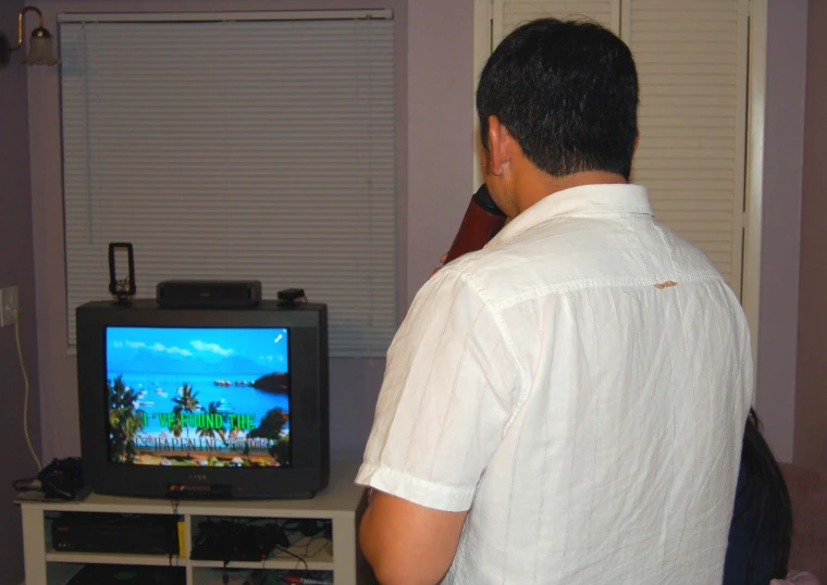 a man in a white shirt plays a video game