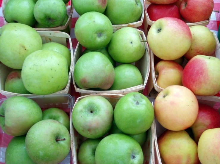 green apples and red apples sit in their packages