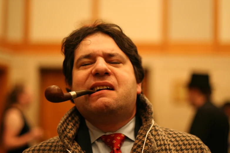 a man wearing a red tie while smoking a pipe