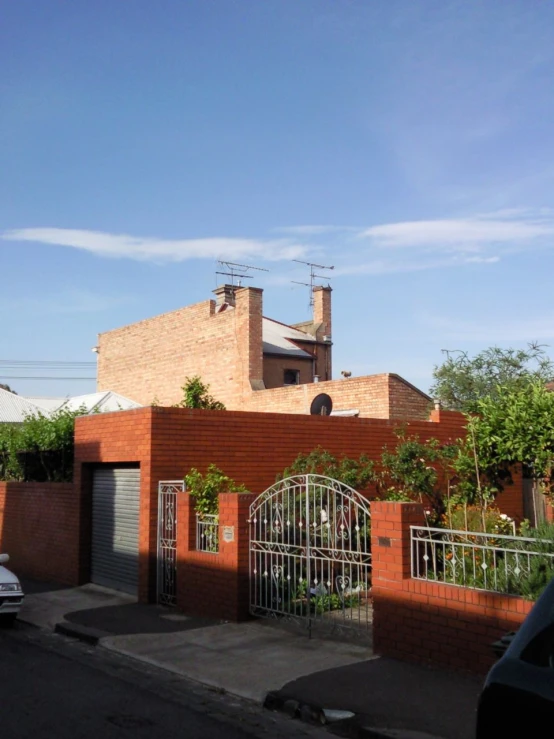 two brick buildings next to a sidewalk on a sunny day