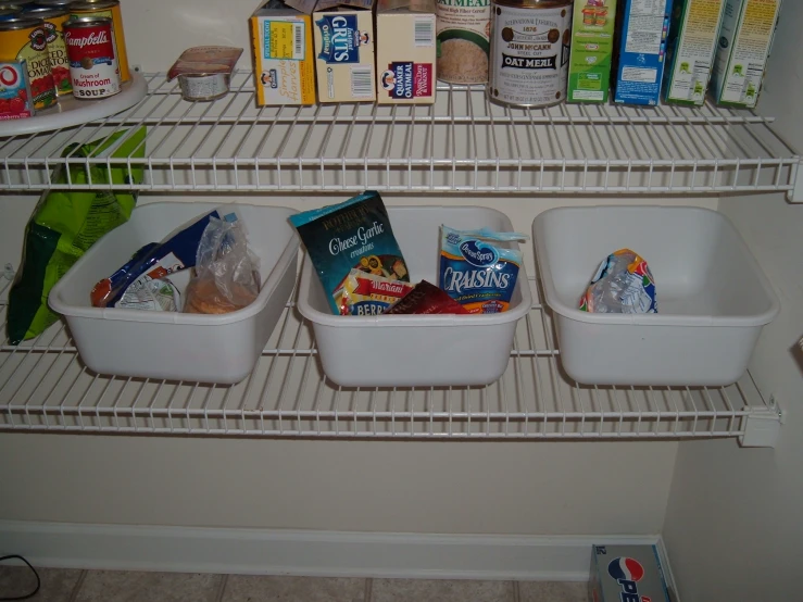 a couple of white baskets sitting on top of a shelf