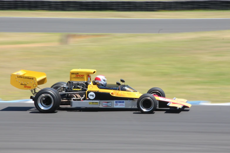 a man riding in a yellow and black race car