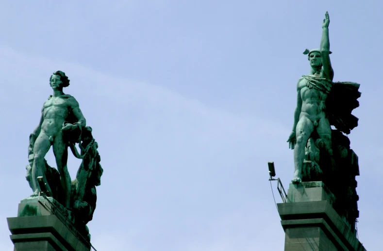 two statues with arms raised standing near each other