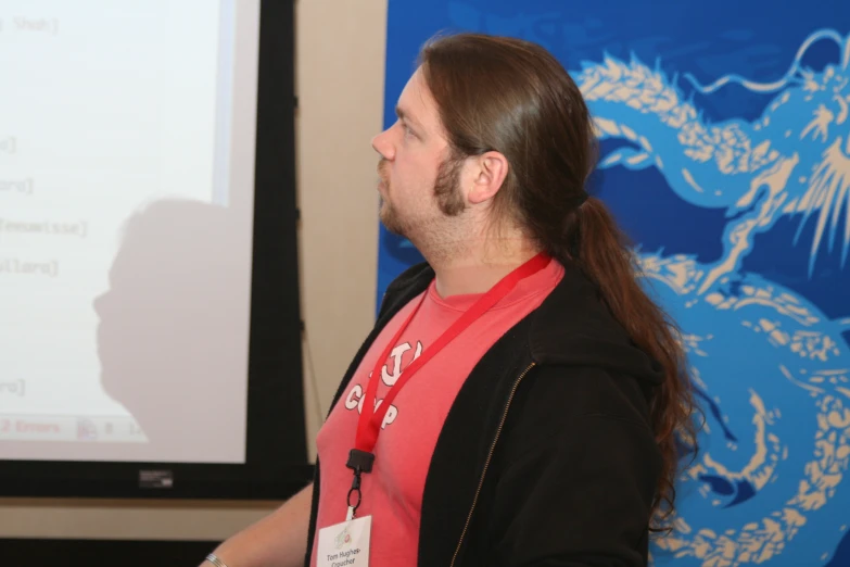 a man stands before a projector while making a presentation