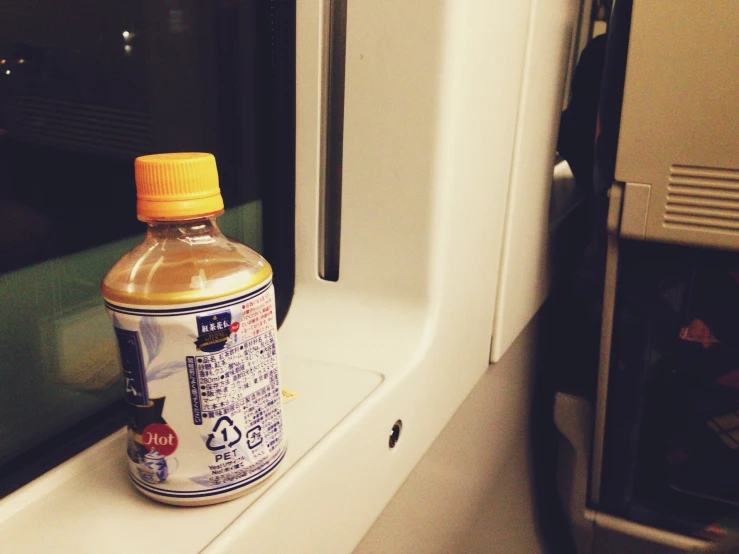 a bottle of liquid on the windowsill of an empty train car