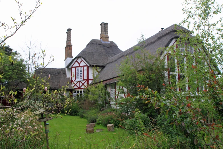 a pretty cottage with green garden in front