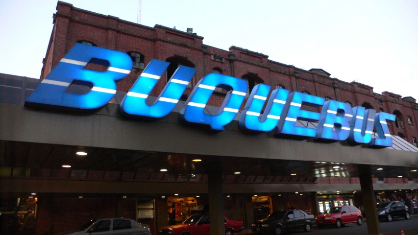 a large sign sits outside a building with a big neon