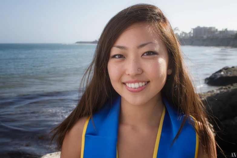 an asian woman posing for a po by the ocean