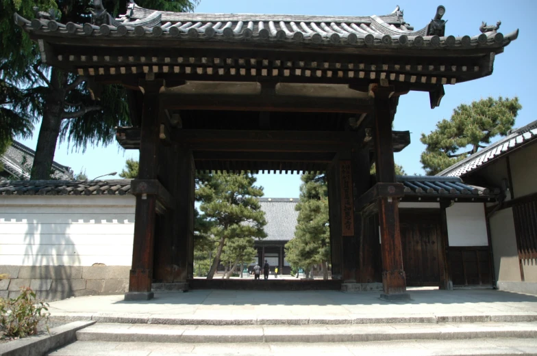 an asian style gate in front of a large house