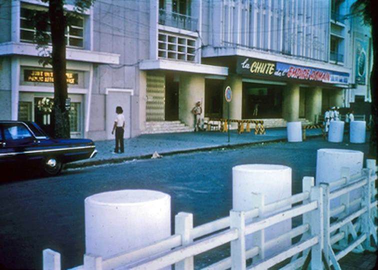 a woman standing in front of a business looking over the fence