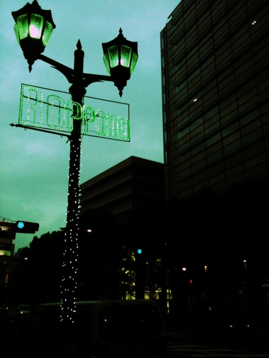 a street light with an green street sign and some buildings