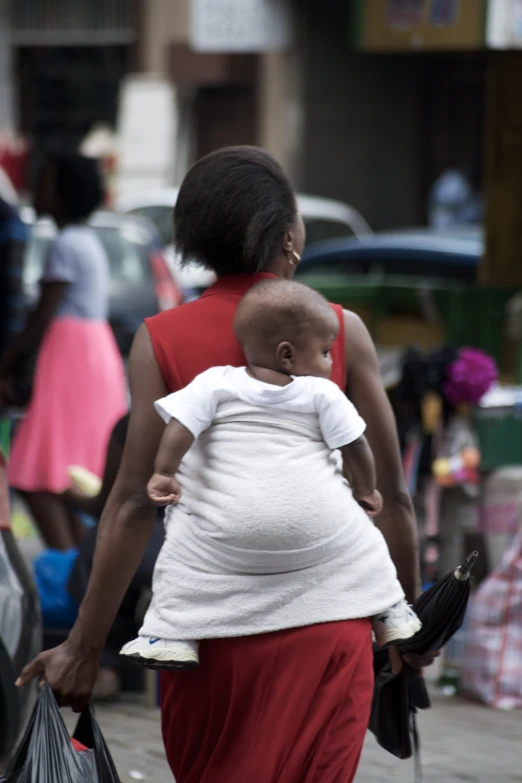 a pregnant black woman walking on a city street