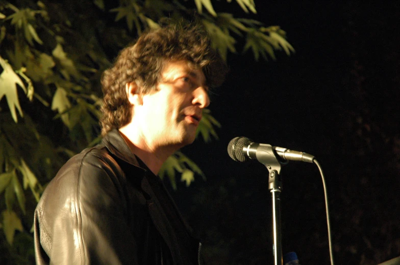 a man is playing an acoustic instrument in front of a microphone