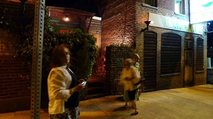 two women are walking in front of an older building