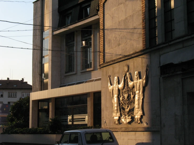 a building with statues on it next to a street