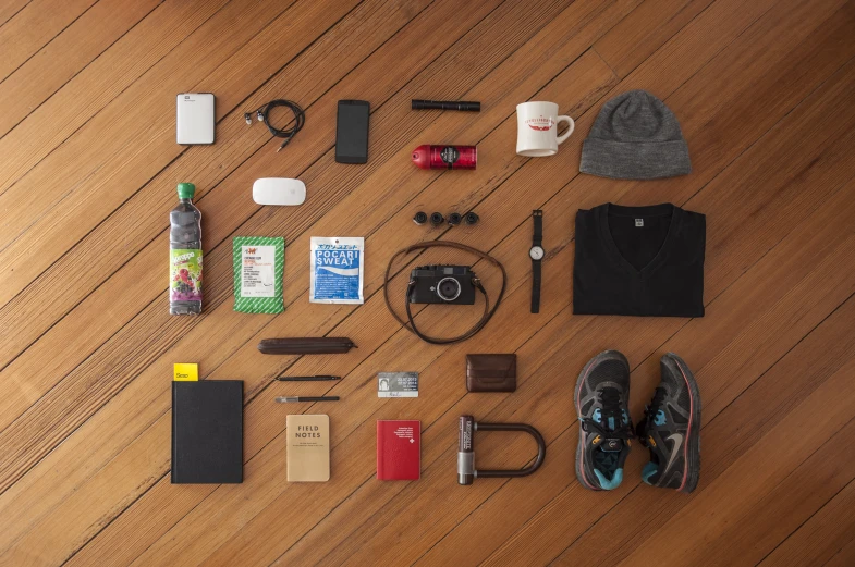 an array of travel items laid out on a floor