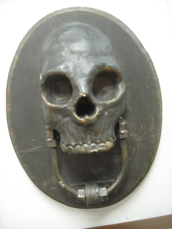 a gray and black clock with a face made of an old fashioned skull