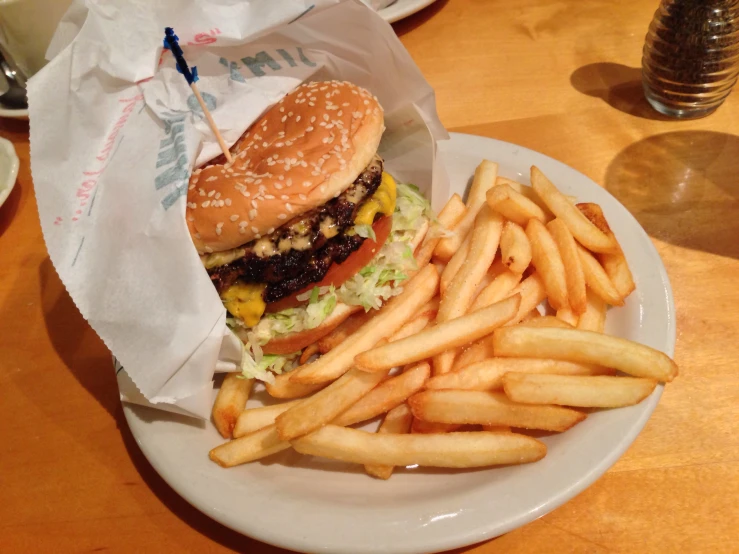 a white plate with a hamburger, fries and drink