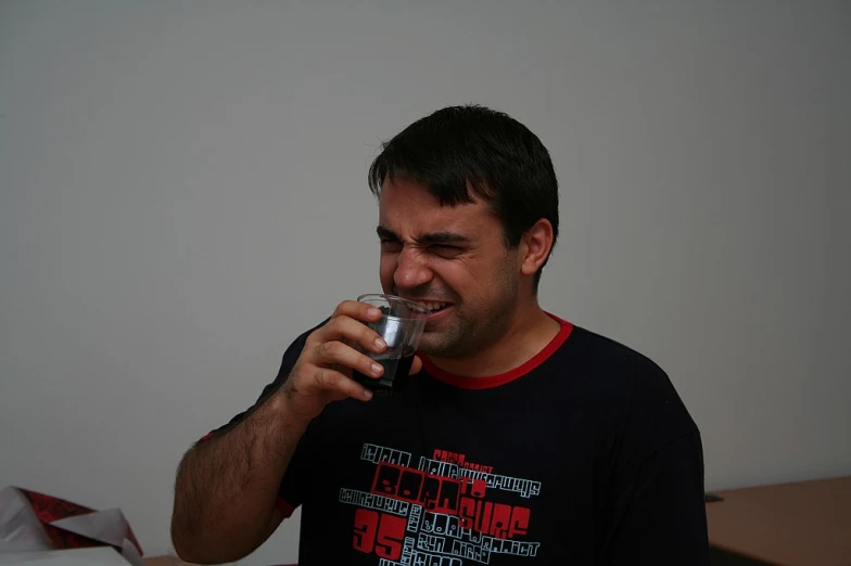 a man holding up a silver drink cup