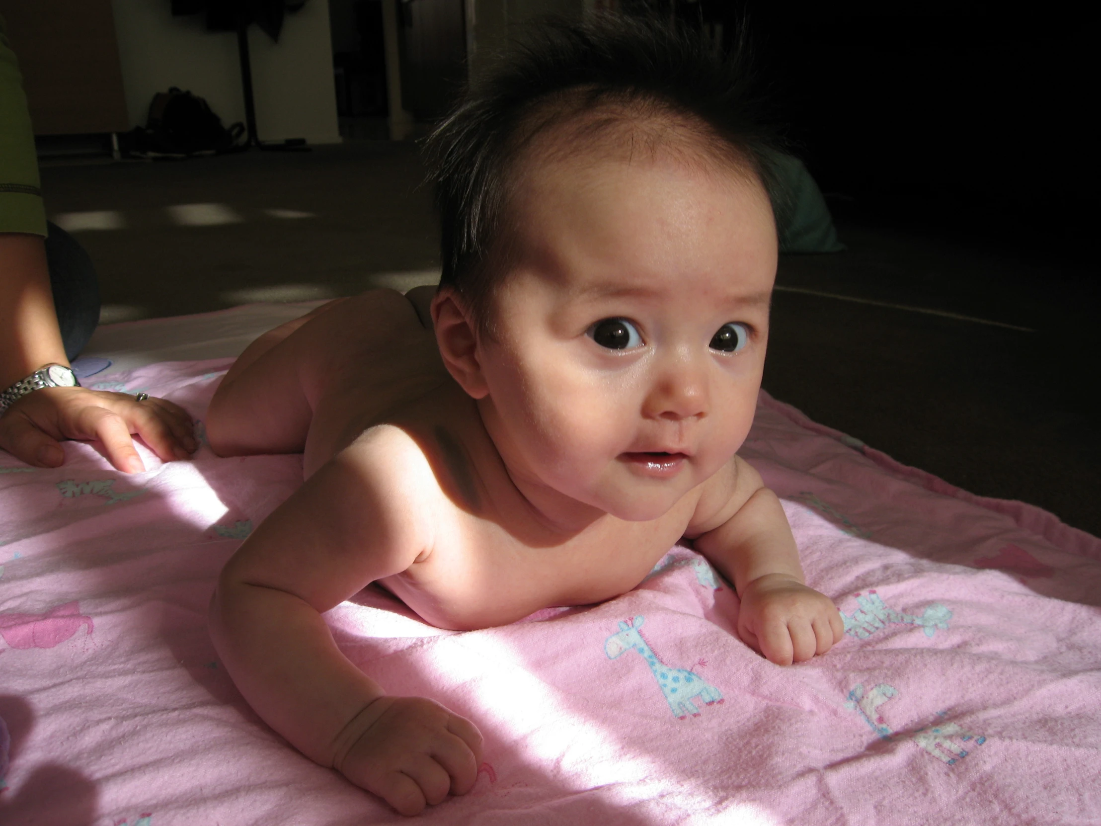 a baby laying on a blanket looking up