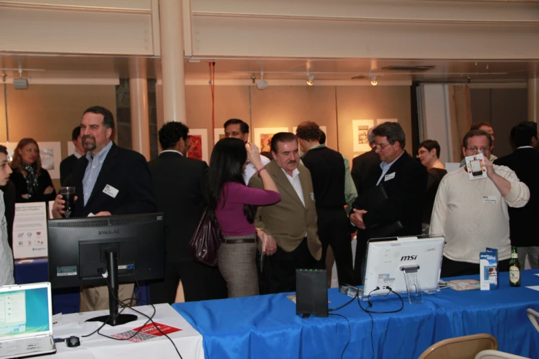 a group of people are talking around at an event