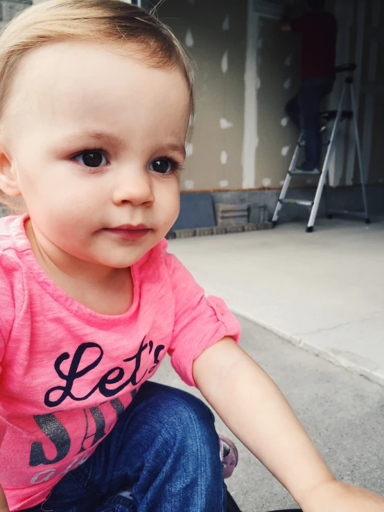 a little girl sitting on top of a skateboard