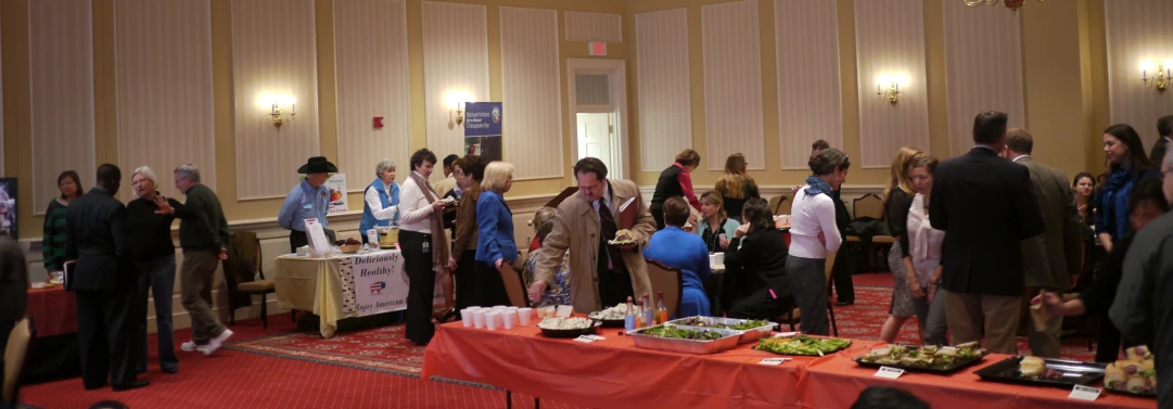 a group of people stand around in line with food