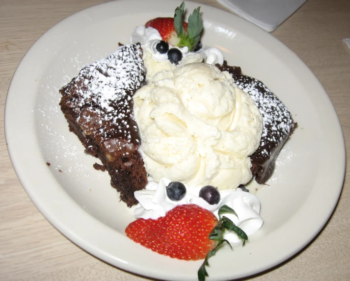 some ding sitting on a white plate with whipped cream on top