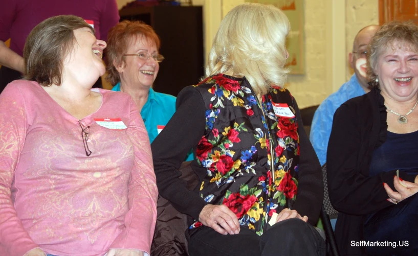 two woman talking to a group of older people