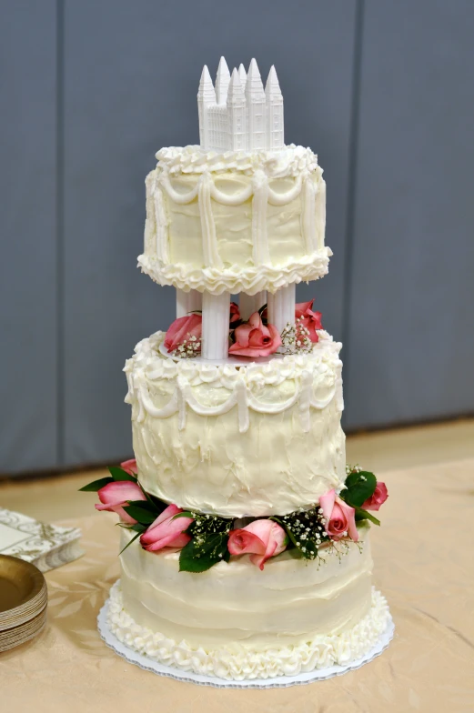 wedding cake sitting on a table next to the wall