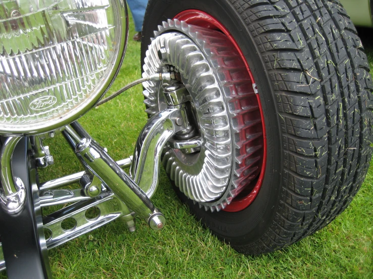 a motorcycle wheel sitting in the grass with spokes in the front