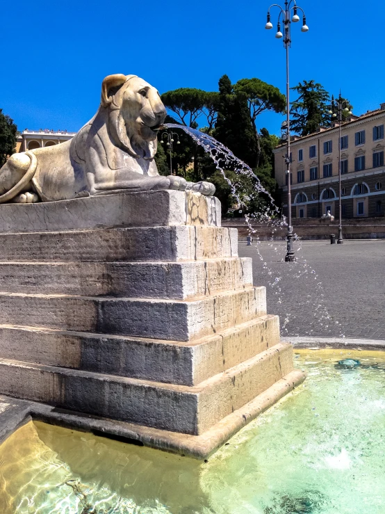 the water fountain is spraying up the two lions