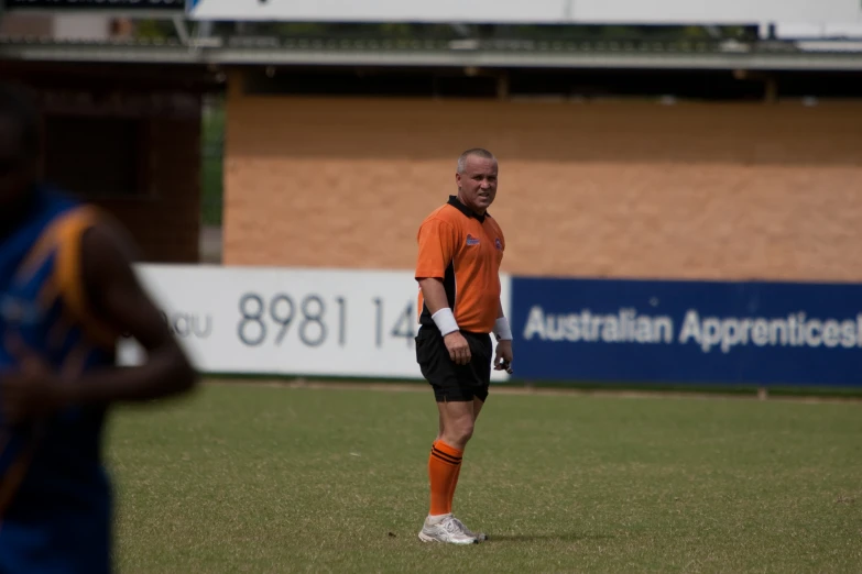 man in orange jersey on a soccer field