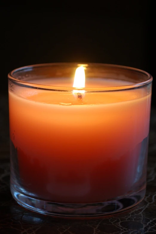 a lit candle in a clear glass bowl