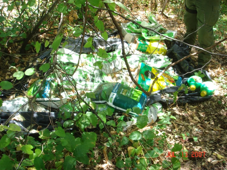 an area where a man stands is littered with empty bottles and items