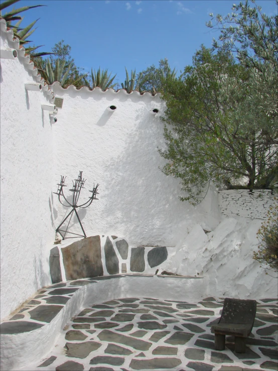 a stone bench in front of an out door garden