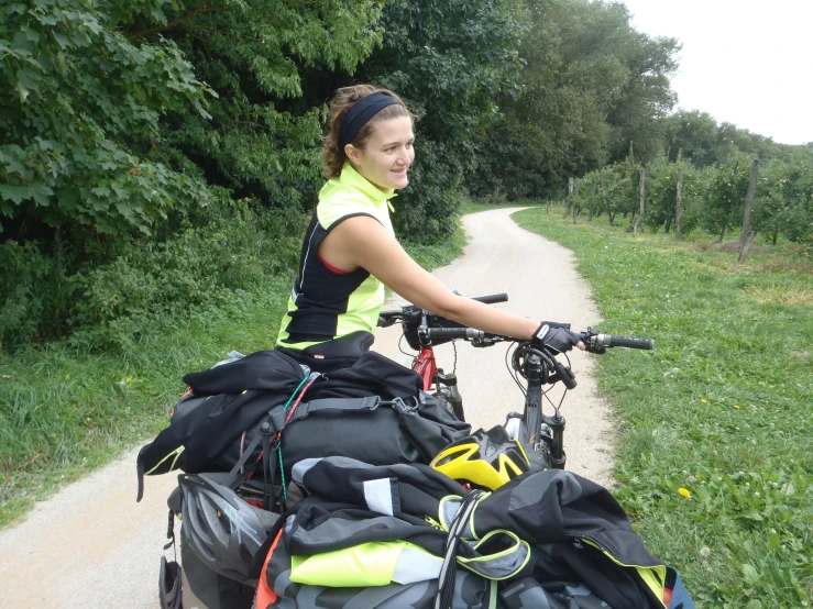 a woman smiles with bags full of bicycle gear