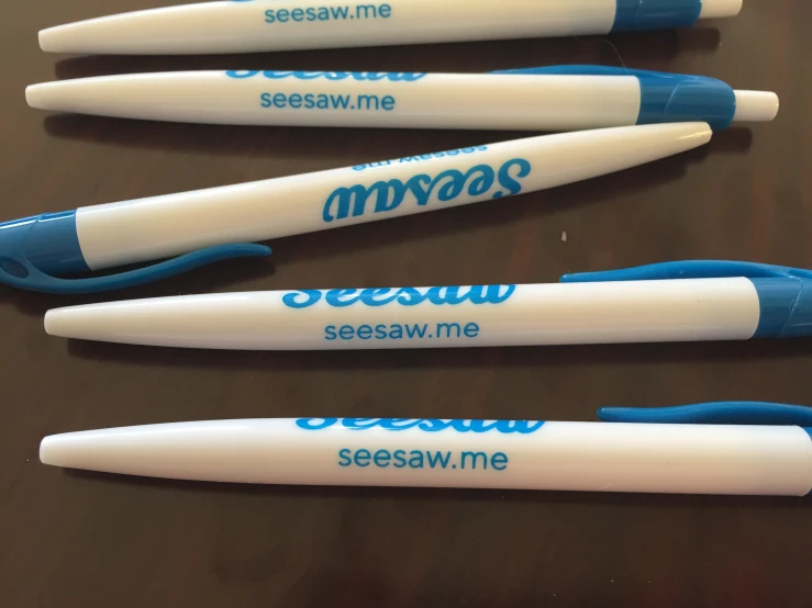 four pens with different writing on them sitting on a table