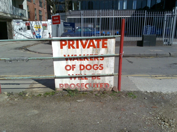 sign on gate warning of dogs to be private