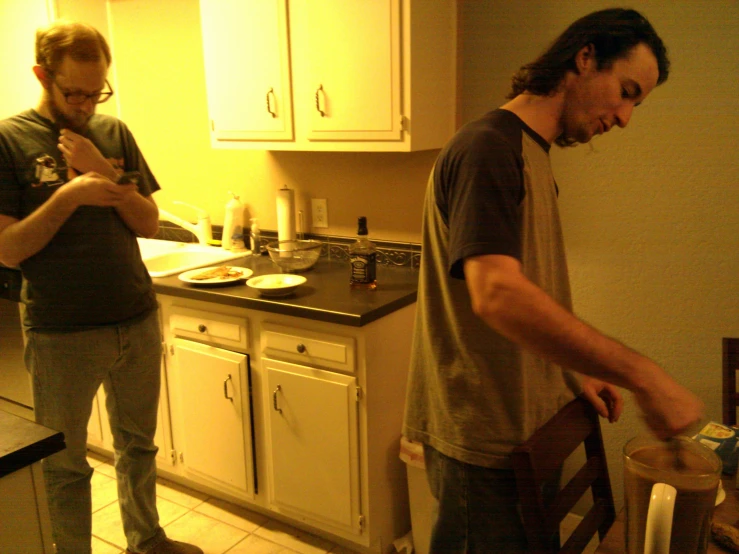 two men in a kitchen making food on a counter