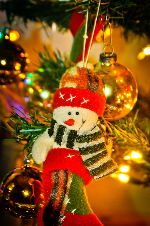 a teddy bear hanging on a christmas tree