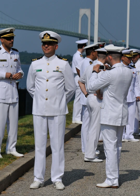 many sailors in white uniforms and men in navy suits