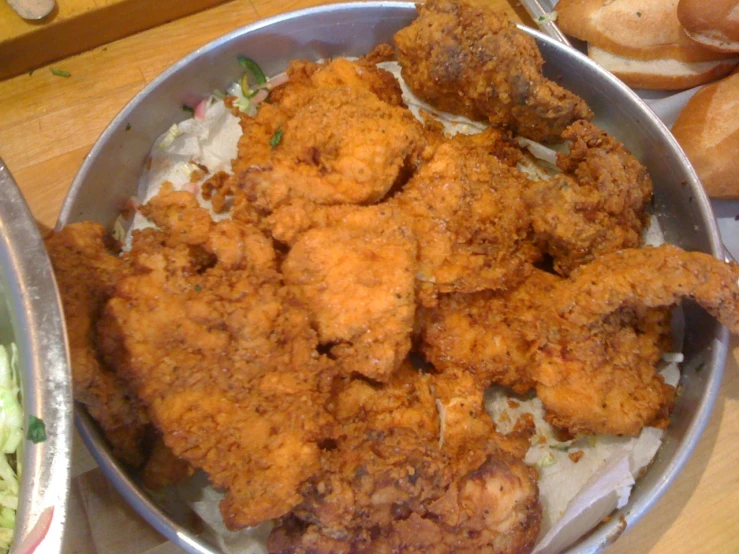 some chicken is in a bowl on a wooden table