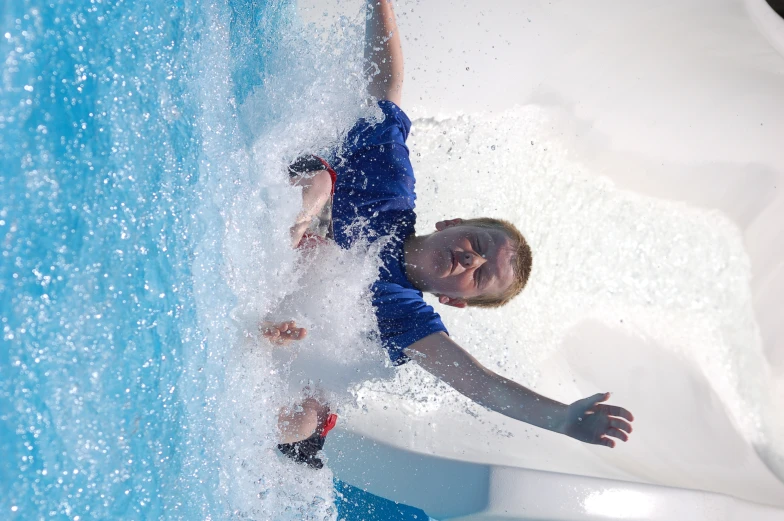 a boy wearing red shorts is swimming in a pool