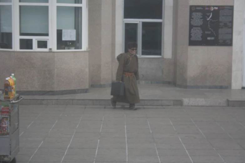 a person in brown is walking on a city street