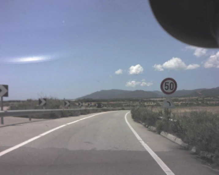 a highway with no cars on it is seen through a car windshield